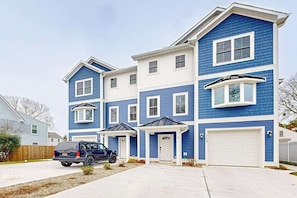 A multi-story residential building with a blue exterior, white trim, and a garage. - Spacious townhouse w/patio, balcony, WIFI, W/D (Rehoboth Beach)