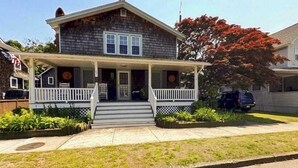 A two-story house with a front porch, a garage, and a driveway.