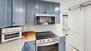 Una cocina con armarios azules, un microondas, una estufa y un horno.
