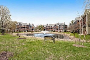 A residential building complex with a central water feature and a bench. - Eagles Landing - updated condo w/two balconies, WiFi, W/D, & AC - great location (Rehoboth Beach)