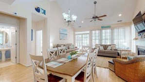 Un amplio espacio de sala con mesa de comedor, sofás y chimenea.