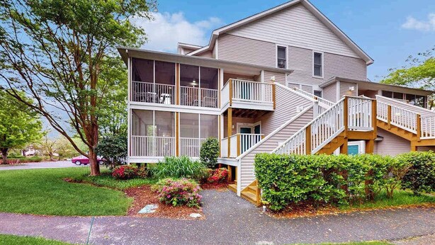 A two-story house with a balcony, a staircase, and a driveway.