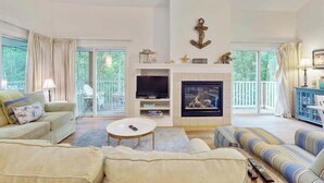 A spacious living room with a fireplace, a television, and a sofa.