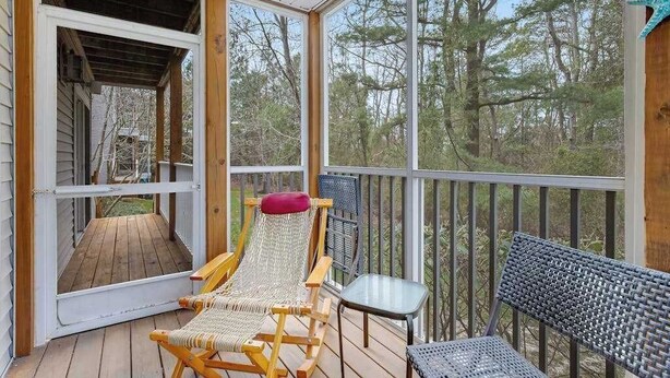 A covered porch with a wooden deck, a hammock chair, a small table, and a chair. - Sea Colony Tennis 1st-floor condo with sauna, gym, & pool (Bethany Beach)
