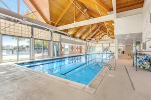 Une piscine intérieure dotée d’un haut plafond, de grandes fenêtres et d’un poste de surveillance bien visible pour les sauveteurs.