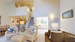 A spacious living area with a high ceiling, a staircase, and a view of a balcony. - Sea Colony Tennis 2nd-floor condo pool & gym (Bethany Beach)