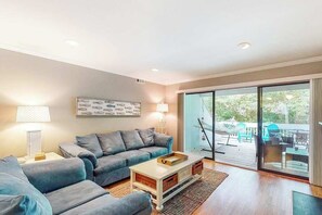 Ein Wohnzimmer mit einer Couch, einem Couchtisch und Blick ins Freie.
