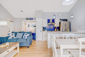 Eine moderne Wohnung mit Wohnzimmer, Küchenzeile und Essbereich.
