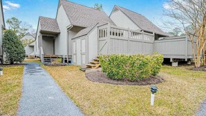 Un quartier résidentiel avec des maisons, un chemin piétonnier dallé et une pelouse bien entretenue.