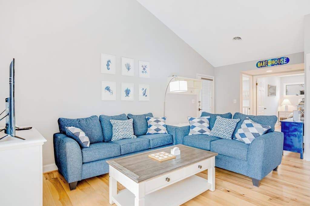 A living room with a blue sofa, a coffee table, and a television.