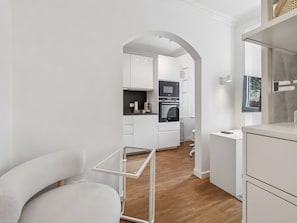 Eine moderne Küche mit weißen Schränken, einer Mikrowelle und einem Backofen.