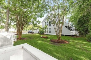 A modern house with a sloped roof, a front porch, and a well-maintained lawn. - Sea Colony 1st-floor condo with sauna, basketball court, & tennis (Bethany Beach)