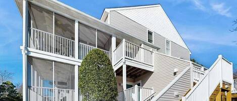 A two-story house with a balcony, a staircase, and a large window.