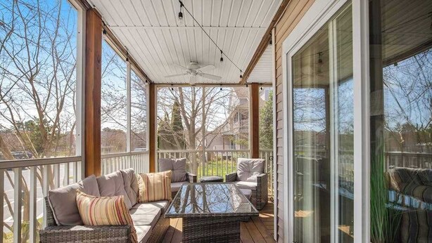 A covered outdoor seating area with wicker furniture, a glass table, and a ceiling fan. - Sea Colony Tennis 1st-floor condo with pool & tennis court (Bethany Beach)