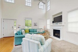 A spacious living room with a sectional sofa, a fireplace, a television, and a ceiling fan. - Bayside Resort house w/ central AC, private washer/dryer, (Selbyville)
