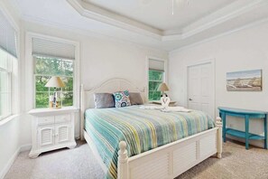 A bedroom with a bed, two bedside tables, a window with blinds, a door, and a painting on the wall. - Bayside Resort house w/ central AC, private washer/dryer, (Selbyville)
