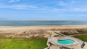 An aerial view of a beachside hotel with a swimming pool, a beach, and the ocean. - Sea Colony Ocean 9th floor condo w/ elevator, tennis court, and pool (Bethany Beach)