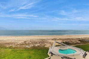 An aerial view of a beachside hotel with a swimming pool, a beach, and the ocean. - Sea Colony Ocean 9th floor condo w/ elevator, tennis court, and pool (Bethany Beach)