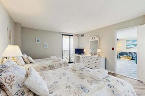 A hotel room with two beds, a dresser, a TV, and a balcony with a view. - Sea Colony Ocean 9th floor condo w/ elevator, tennis court, and pool (Bethany Beach)