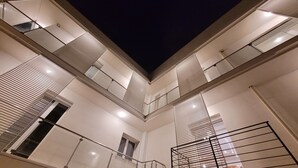 Un edificio a più livelli con balconi, ringhiere e cielo notturno.
