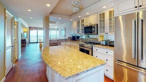 A spacious kitchen with granite countertops, stainless steel appliances, and white cabinetry. - Sea Colony oceanfront 15th-floor condo with pool & tennis/basketball courts (Bethany Beach)