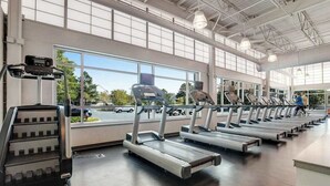 A gym with treadmills, a stair climber, and large windows. - Sea Colony oceanfront 15th-floor condo with pool & tennis/basketball courts (Bethany Beach)