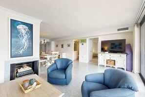 Ein modernes Wohnzimmer mit Kamin, einem großen Gemälde und einem Fernseher.