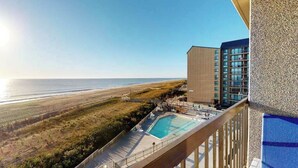 A hotel with a pool, a view of the beach, and a building with multiple floors. - Sea Colony Ocean 5th floor condo w/ balcony, shared sauna, and pool (Bethany Beach)