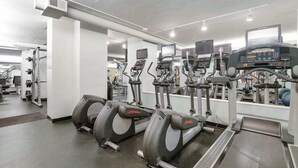 Een fitnessruimte met loopbanden, elliptische trainers en gewichtstoestellen.