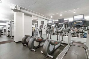 Ein Fitnessstudio mit Laufbändern, Crosstrainern und Kraftgeräten.