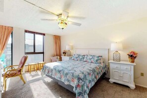 A bedroom with a bed, a chair, a nightstand, a lamp, and a ceiling fan. - Sea Colony 2nd floor condo with pool, tennis, balcony, washer/dryer, elevator (Bethany Beach)
