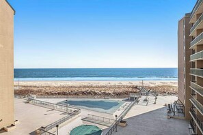 Ein Poolbereich auf dem Dach mit Blick auf Strand und Meer.