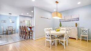 Un espace repas comprenant une table ronde, des chaises et un luminaire suspendu.