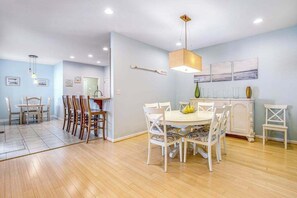 A dining area with a round table, chairs, and a hanging light fixture. - Bayside Resort townhouse with golf on-site, pool access, fireplace, & central AC (Selbyville)