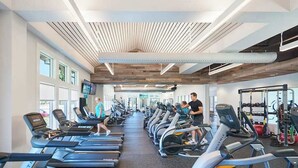 Un gimnàs amb cintes de córrer, bicicletes estàtiques i aparells de musculació.