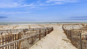 Ein Strandweg mit Holzzaun, der zum Meer führt.