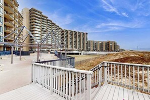 A beachfront hotel with multiple high-rise buildings, a boardwalk, and a sandy beach. - Sea Colony oceanfront condo with pools, hot tub, sauna, balcony & pickleball (Bethany Beach)