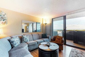 A modern living room with a sofa, coffee table, and a view of the outdoors. - Sea Colony Ocean 1st floor condo w/ tennis court, free WiFi, and elevator (Bethany Beach)
