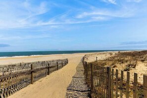 A beach with a wooden fence and a stone pathway leading to the water. - Sea Colony Ocean 5th floor condo w/ shared sauna, elevator, and pool (Bethany Beach)