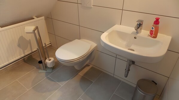 A bathroom with a toilet, sink, and hand dryer. - Holiday Apartment for 3 Guests (40 m²) in Gerswalde (Gerswalde)