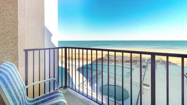 A balcony with a view of the beach and a pool area. - Sea Colony Ocean 5th floor condo w/ tennis court, pool, and elevator (Bethany Beach)