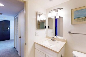 A bathroom with a sink, mirror, and toilet. - Sea Colony Ocean 2nd floor condo with sauna (Bethany Beach)