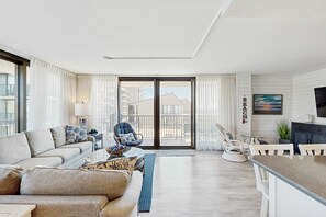 A modern living room with a sofa, armchairs, a coffee table, and a dining area. - Sea Colony Ocean 2nd floor condo w/ elevator, gym, and free WiFi (Bethany Beach)
