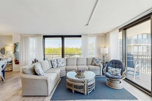 Una sala de estar moderna con un sofá modular, una mesa de centro redonda y un sillón.