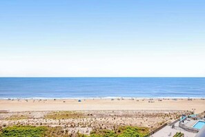 Blick auf einen Strand mit Schwimmbad und einer Umzäunung.