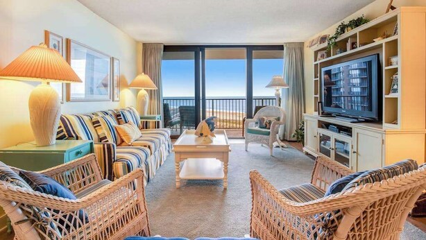 A living room with wicker furniture, a television, and a view of the ocean. - Sea Colony Ocean 6th floor condo w/ pool, gym, and free WiFi (Bethany Beach)