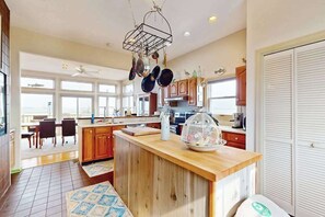 Una cocina amplia con armarios de madera, una isla central y un colgador para ollas.