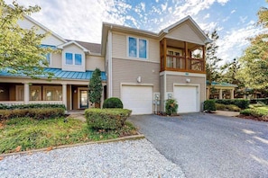A two-story house with a covered front porch, a garage, and a balcony. - Sea Colony Tennis Townhouse w/ Pools, Tennis, Pickleball & Gym (Bethany Beach)