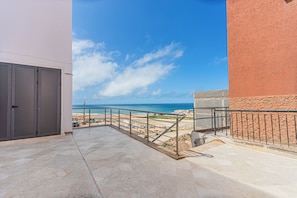 Ein Balkon mit Blick auf Strand und Meer.