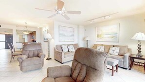 A spacious living room with a ceiling fan, two sofas, a chair, and a lamp. - Sea Colony Ocean 9th floor condo w/ balcony, gym, and free WiFi (Bethany Beach)